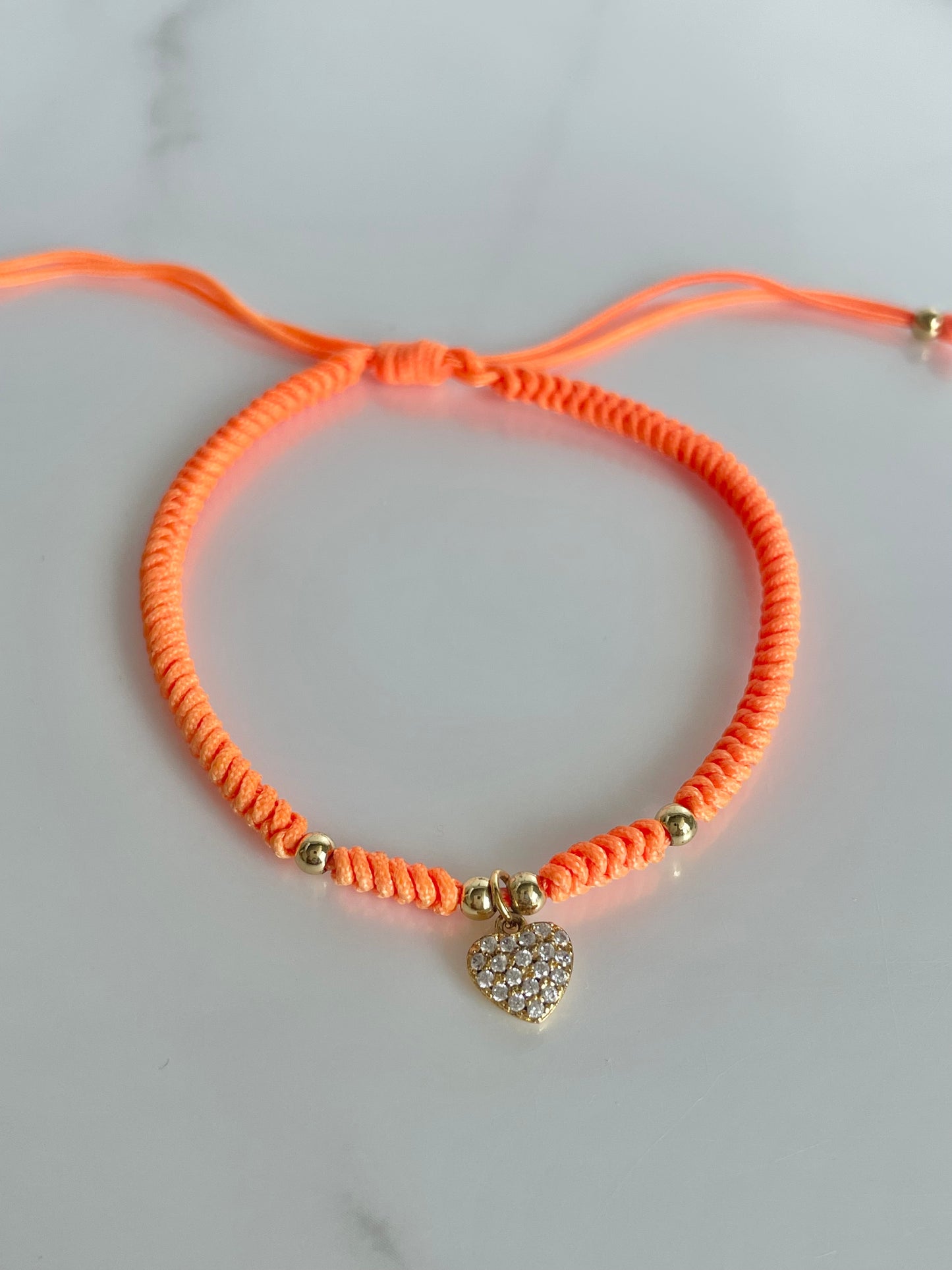 Pulsera tejida naranja, corazón